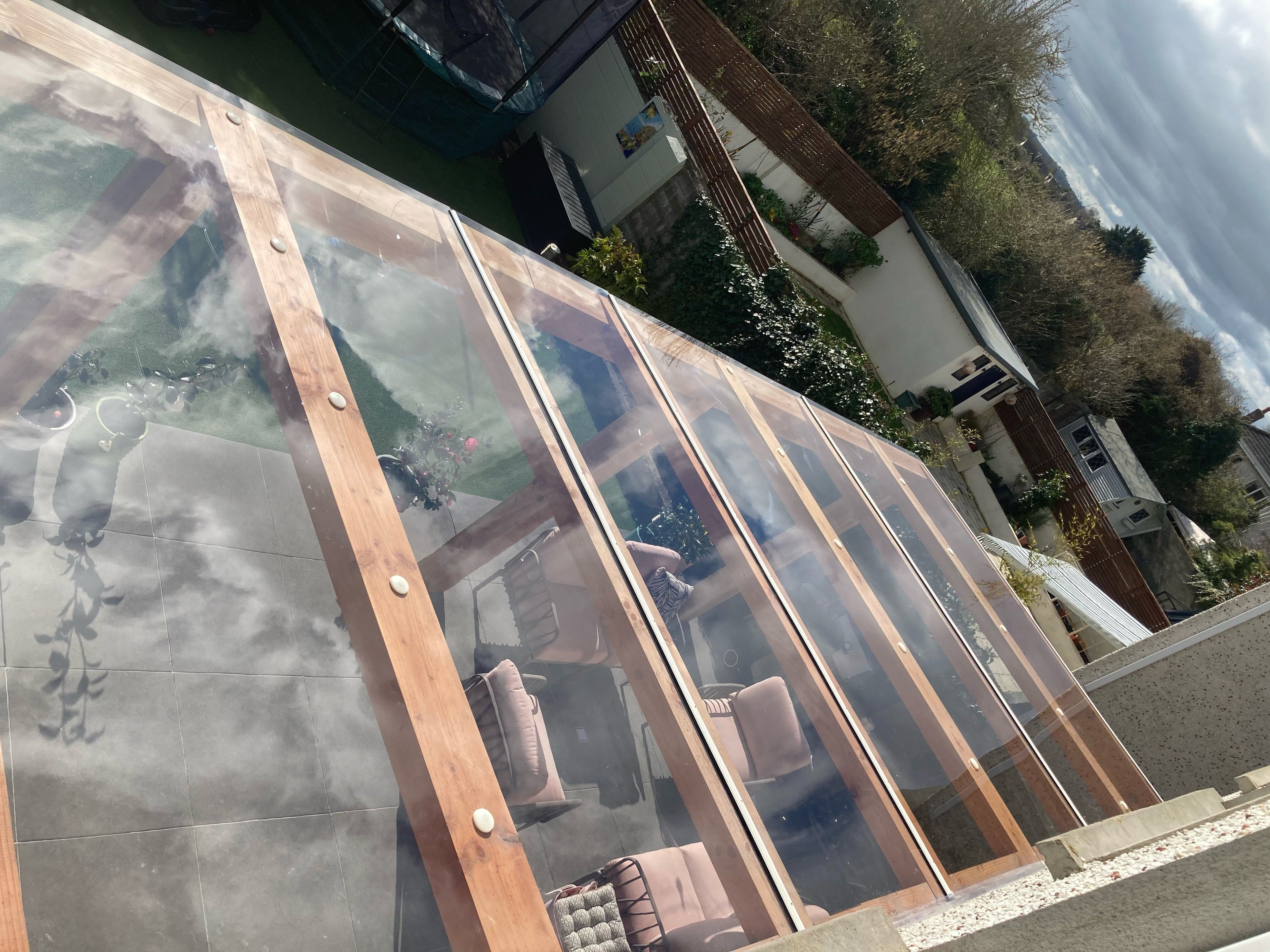 Solid polycarbonate fitted on a wooden pergola using Capex glazing bars for sheet joining